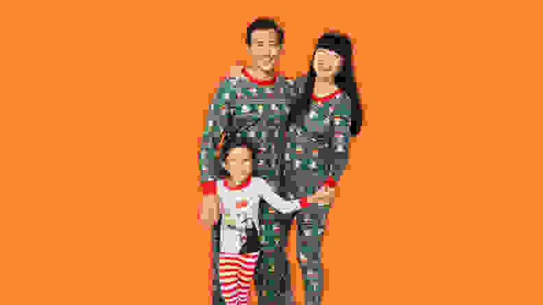 A father, mother, and son wearing Hanna Andersson Star Wars Grogu holiday matching family pajamas.