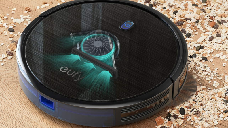 A Eufy robovac vacuums over a carpet.