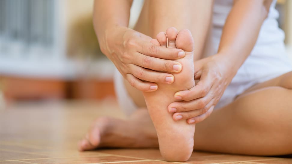 A woman rubbing her foot.