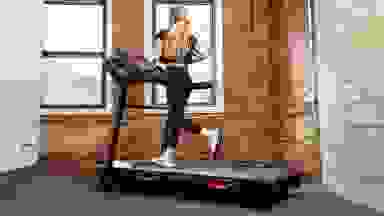 A woman runs on a Bowflex BXT8J treadmill.