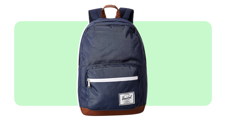 A Herschel backpack in the color navy on a green and white background.