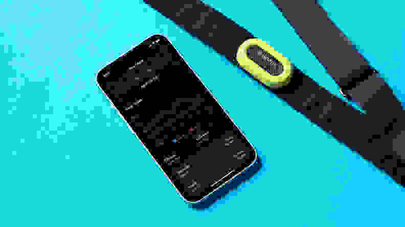 The Garmin HRM-Pro next to a smart phone featuring the Garmin HRM-Pro app tracking a heart rate.