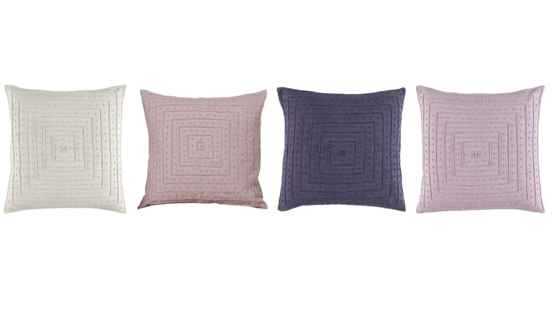 Four pillows in various shades of purple.