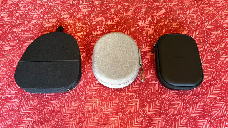 The Sony Wh-1000XM5, XM4, and Bose QC45 sit inside their cases on a red table cloth.