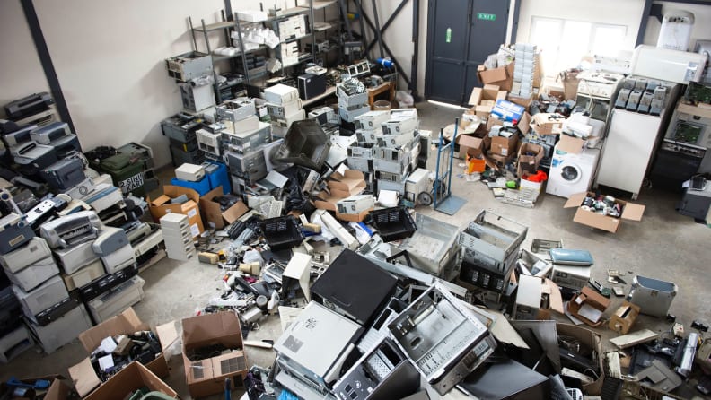 Obsolete computer electronics equipment and appliances are in different piles around a recycling facility.