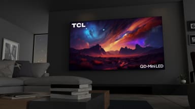 The 115-inch TCL QM89 mini-LED TV displaying colorful, abstract imagery in a modern living room setting