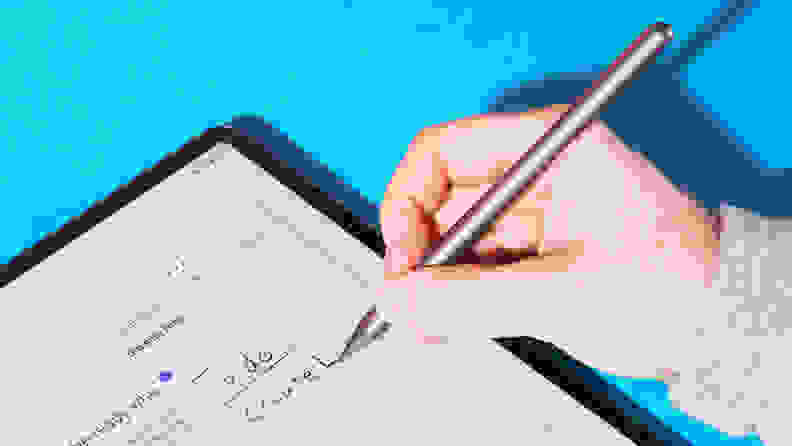 Close-up of a hand using the tablet's pen to write.