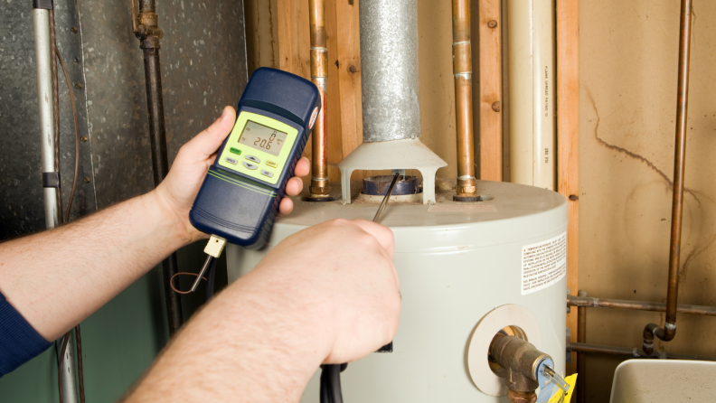 Technician checking the carbon monoxide levels on a gas hot water heater