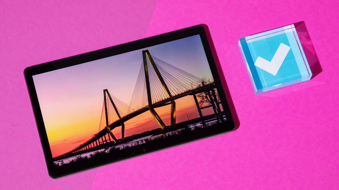 A Lenovo Tab M10 Plus (Gen 3) sits on a hot pink background. The Tablet's display shows a suspension bridge at sunset.