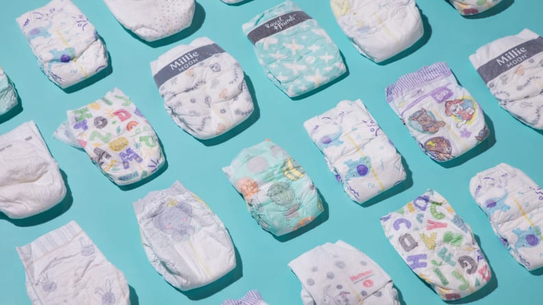 An array of baby diapers from Pampers, Millie Moon, Coterie and Honest lined up in a row.