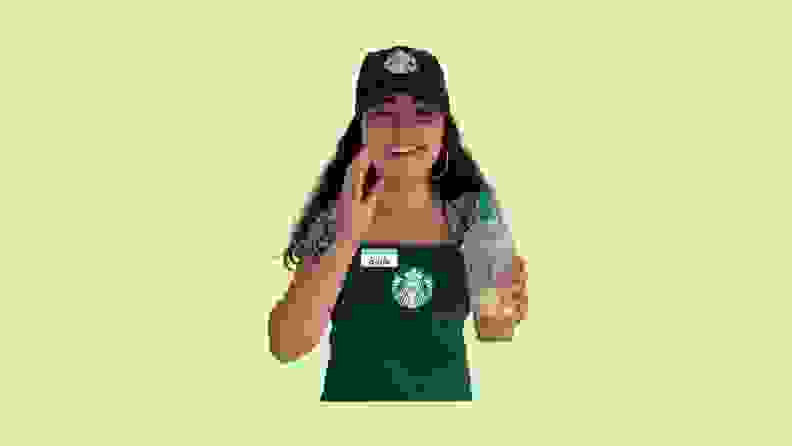 A child modeling a Starbucks barista uniform in front of a green background.