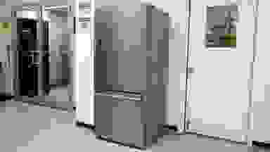 A stainless-steel refrigerator stands in a white lab environment