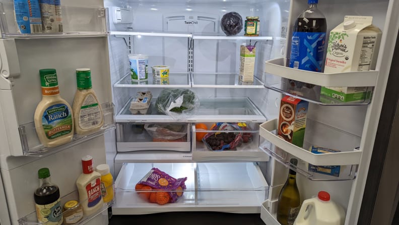 Close-up of interior of fridge completely filled with food.