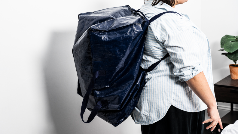 A person wearing the blue moving bag as a backpack.