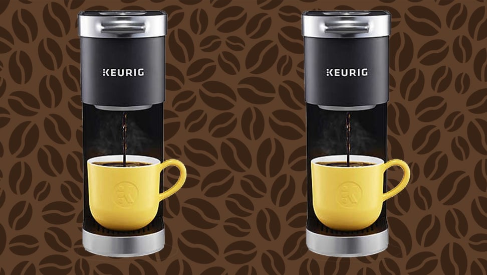 Two black Keurig coffee makers brewing coffee into yellow mugs in front of brown coffee bean background.