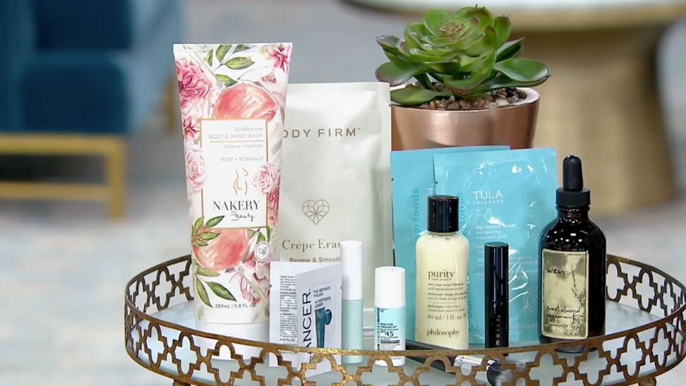 An image of the beauty products included in the Beauty with Benefits gift box, including a large bottle of rose body wash, several skincare pads from TULA, a Wen tea tree cleanser, Philosophy, Tarte, and Mally Beauty products.