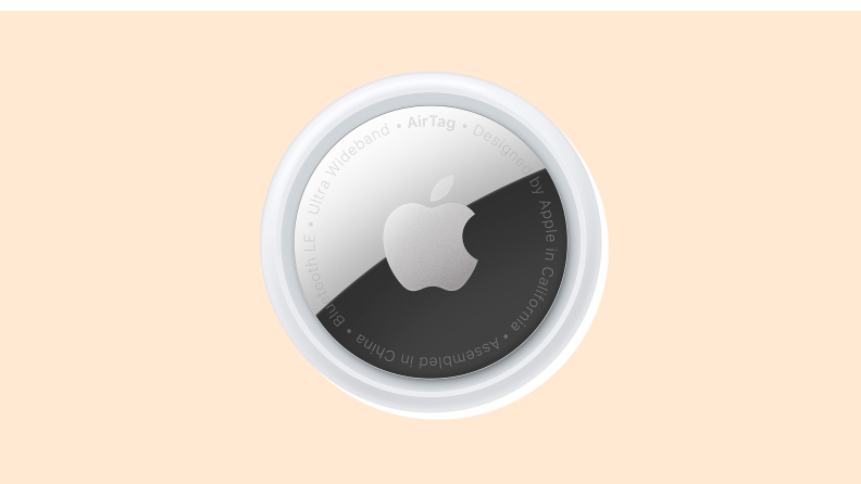 An Apple Airtag on a vanilla-colored background.