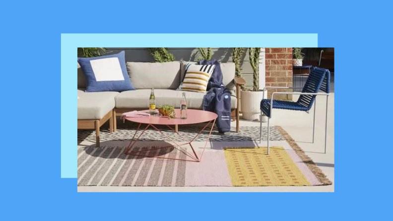 An ikat print rug on a patio against a blue background.