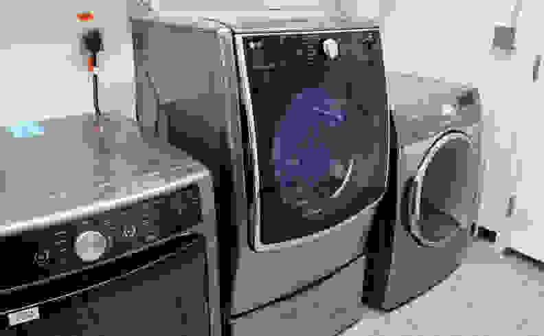 The LG DLEX5000V flanked by two conventional dryers, atop the WDP4V pedestal—which happens to feature a drawer for storage.