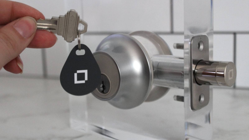 The Level Lock Plus Connect with a key fob hanging in front of the exterior lock face.