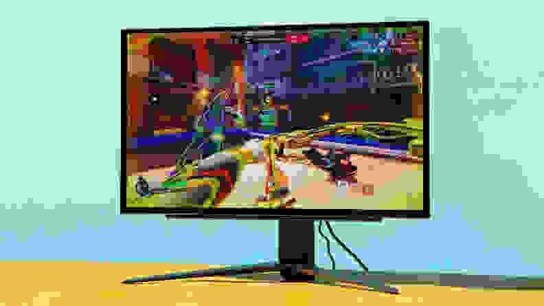 LG UltraGear OLED 27GR95QE-B gaming monitor on top of yellow desk.