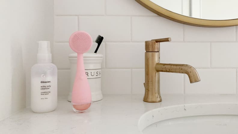 A pink PMD Brush on a kitchen sink