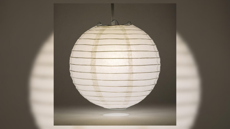 A lit paper lantern in a dark room.