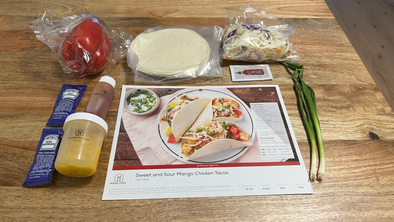 A Home Chef recipe card for chicken tacos surrounded by ingredients.