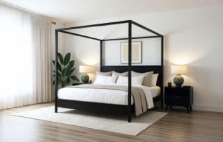 A black wooden canopy bed from Plank+Beam