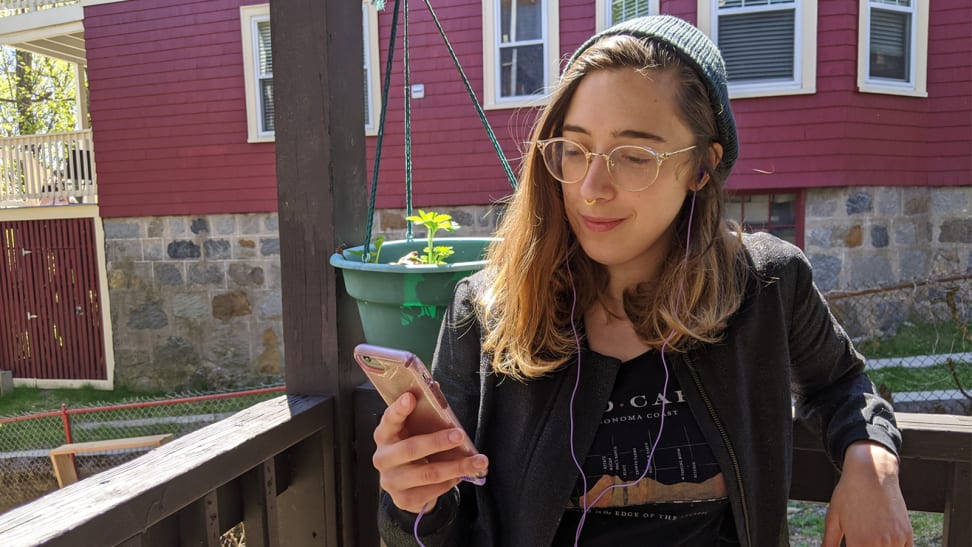 Woman listens to audio on her phone