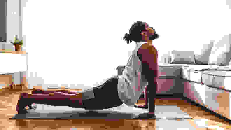 A man in cobra pose on a yoga mat.