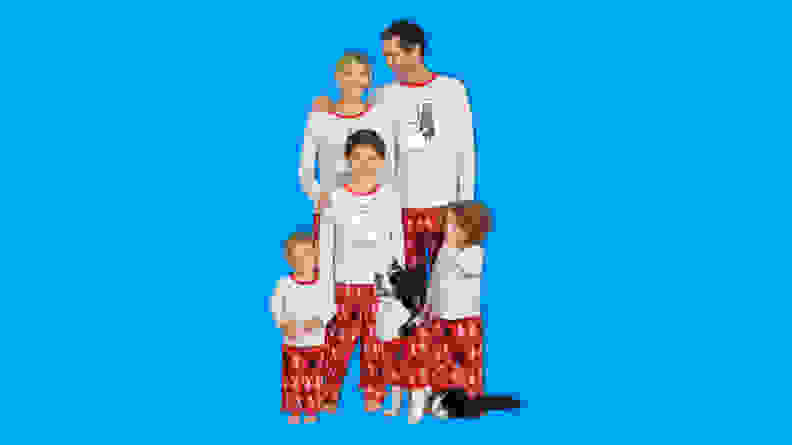 A family wearing PajamaGram Star Wars Christmas Pajamas on a blue background.