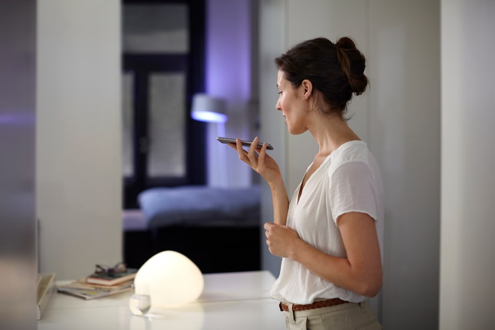 A woman uses Siri to control her Philips Hue lights