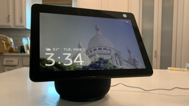 A black Amazon Echo Show 10 with its large screen sits on a table.