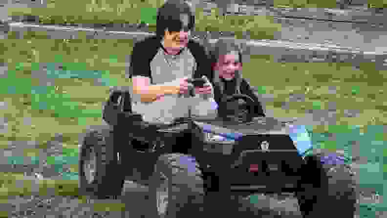 Teenage boy driving buggy with young passenger