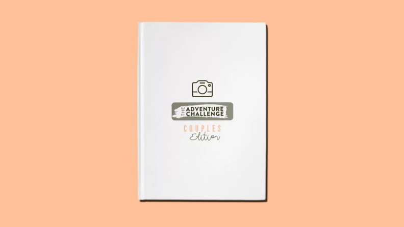 A white hardcover journal that reads The Adventure Challenge Scrapbook: Couples Edition on an orange background.