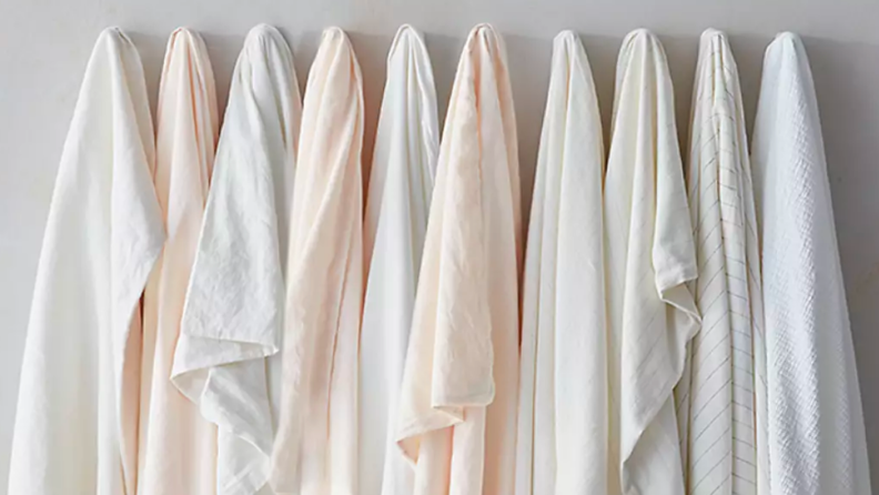 An image of several different linens hanging next to one another in a line.