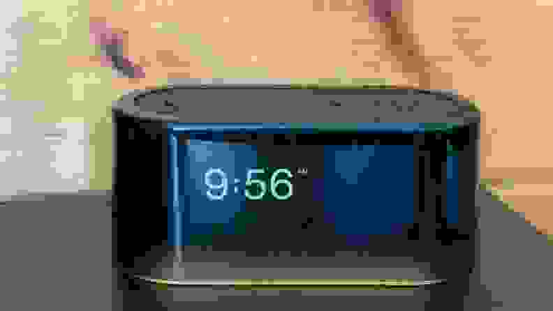 Black nightstand clock with 9:56am displaying and a light along the bottom