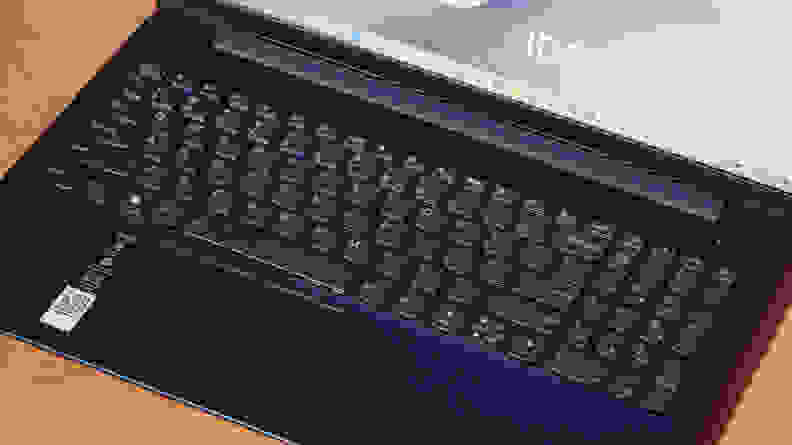 A top-down view of a laptop keyboard against a two-tone surface.