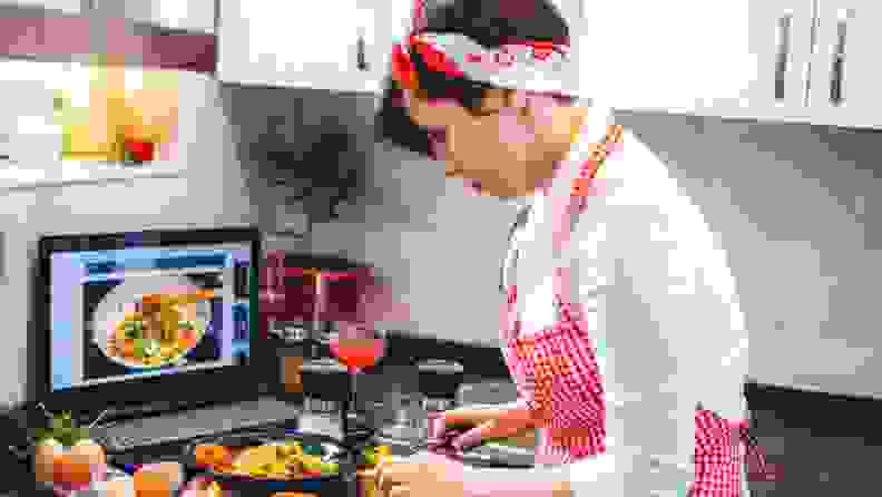 a woman in a red check apron cooks