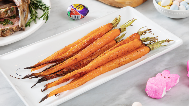 A platter of whole roasted carrots surrounded by Easter candy.