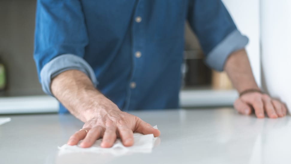 一个男人正在用消毒擦拭布擦拭厨房台面