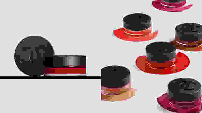On the left: A jar of lip and blush cream that's tinted red sitting on a shelf. On the right: Five blush and lip tints of different colors in their jars capped with black Chanel logo-imprinted lids.