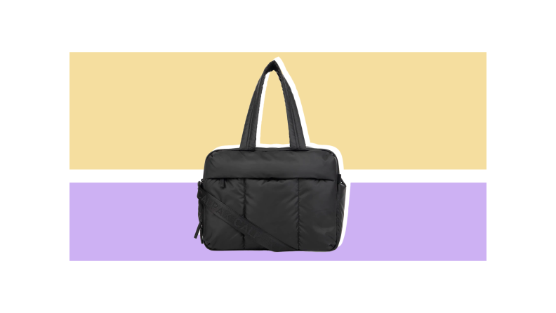 A black Luka duffel against a light gold and purple background.