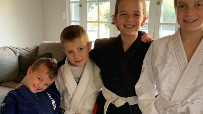 Children smiling together while wearing karate gis.