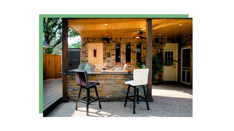 An outdoor kitchen with two barstools.