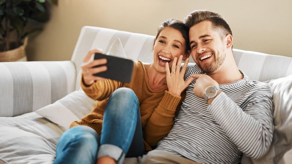 Newly engaged couples sitting on couch