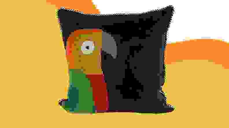 A parrot pillow against a yellow background