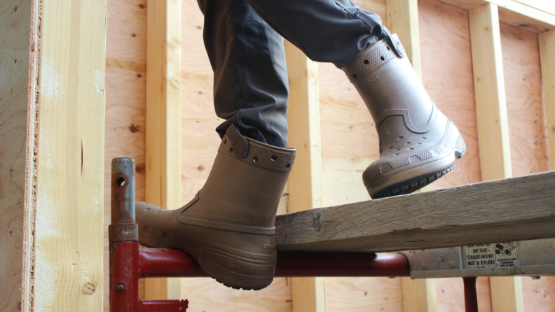 Man wearing Croots while standing on a beam