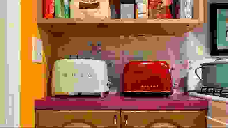 A SMEG mint green toaster and a Galanz red toaster side-by-side.